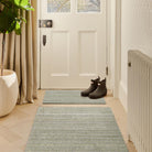 Candy Green Washable Doormat with a stripe design, styled in a doorway.