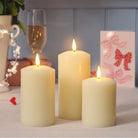 Three LED candles of different sizes on a table